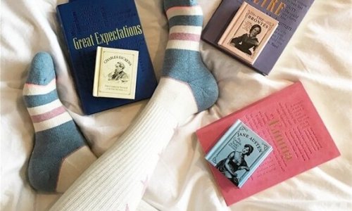 Person i seng med bøger nyder at læse før sengetid