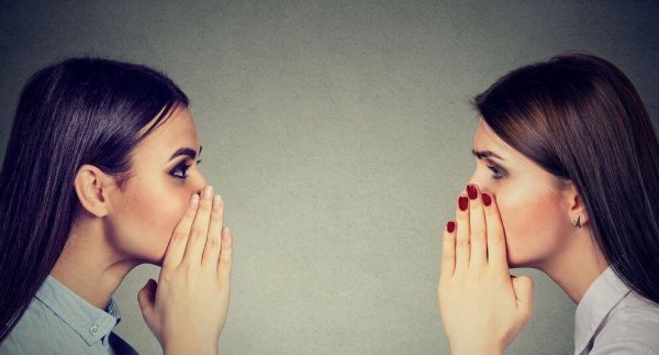 To kvinder, der kan lide at sladre, hvisker til hinanden