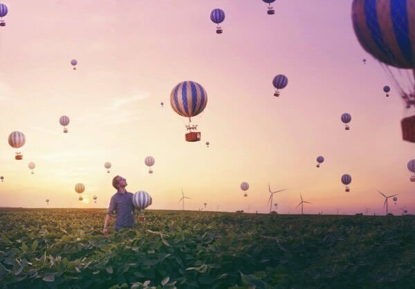 Mand fanger luftballoner på mark i sin søgen efter lykke gennem eudaimonia