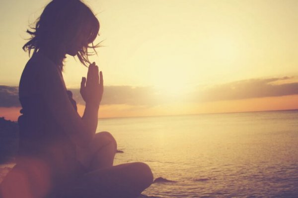 kvinde mediterer ved strand for at undgå tilbagefald af sorg