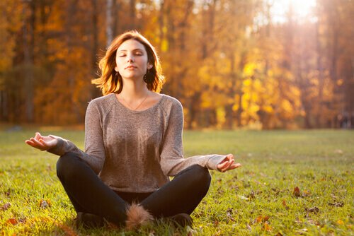 Kvinde mediterer i natur for at undgå at blive mentalt overvægtig