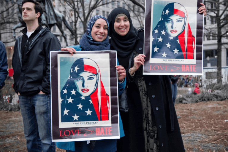Kvinder holder plakat op i kamp mod xenofobi