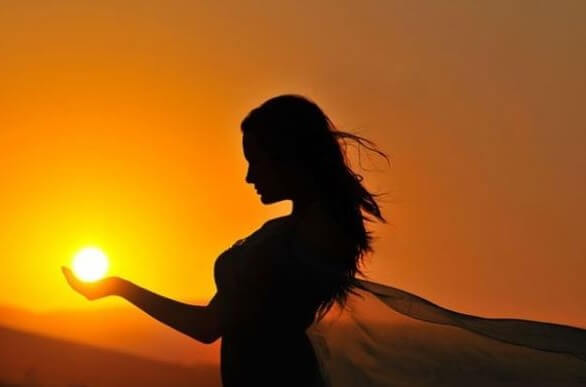Kvinde med sol i hånd ønsker at genvinde positiv energi