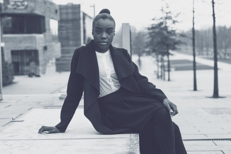 Kvinde i sort foran bygninger