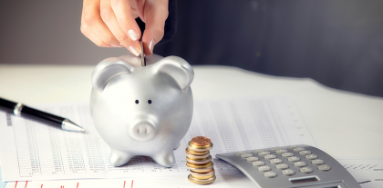 Person kommer mønter i sparegris