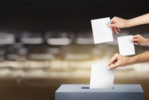 Personer kommer stemmer i stemmeboks