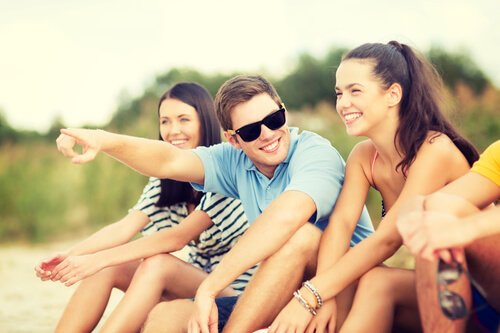 Venner griner sammen på strand