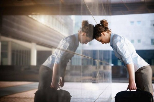 stresset kvinde sætter hoved mod væg