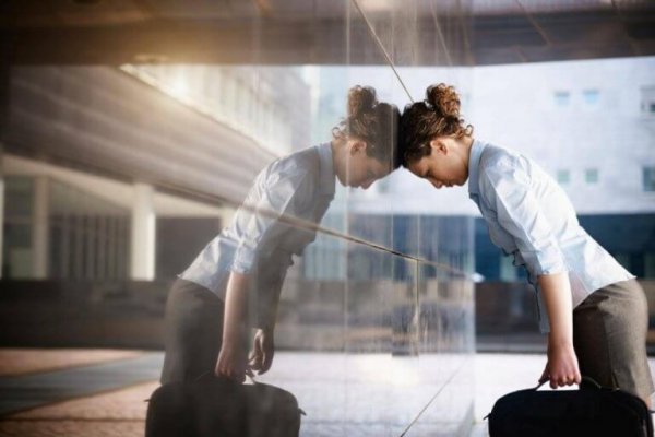 kvinde læner hoved op af vindue som resultat af mangel på tryptofan og serotonin