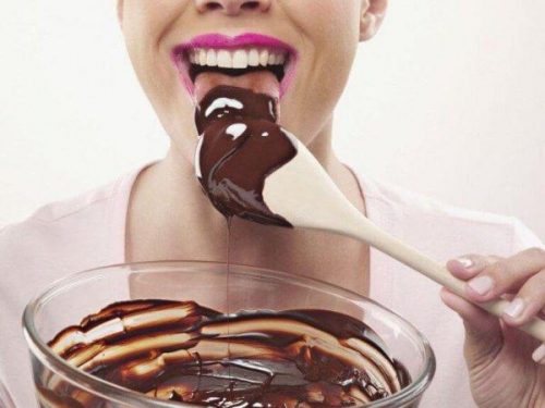 Kvince slikker smeltet chokolade af træske fra en glasskål