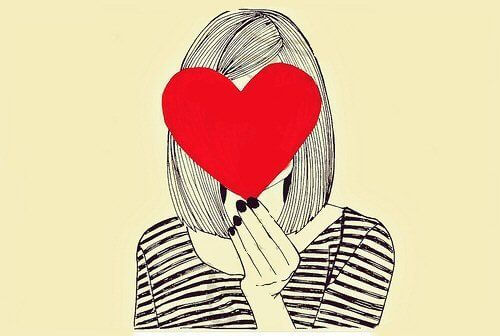 Kvinde holder et hjerte foran sit ansigt. Forelsket i dig selv. 