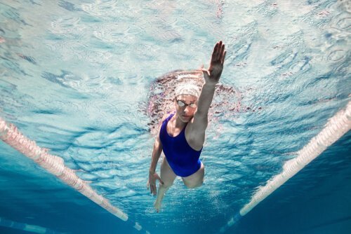 Kvinde svømmer i poolen i nyder fordele ved svømning