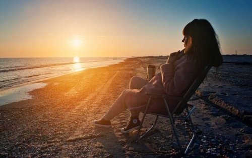 Kvinde sidder og kigger på solnedgang for at få et nyt perspektiv