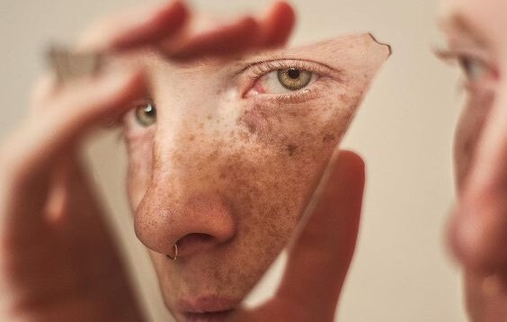 En kvinde kigger på sig selv i et ødelagt spejl. din egen allierede