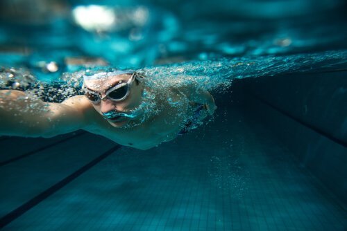 Mand svømmer under vandet og nyder fordele ved svømning