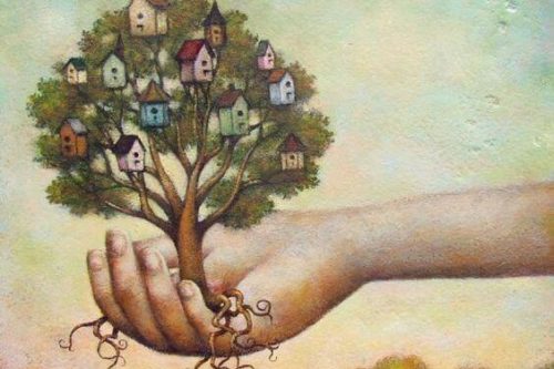 Holder et træ i hånden med rødder