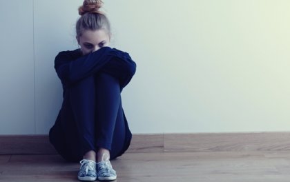 Pige sidder på gulvet