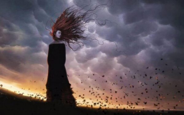 Kvinde i sort står i uvejr