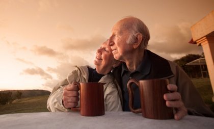 Ældre par får en kop kaffe sammen og nyder sund aldring