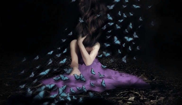 Kvinde i lilla kjole med sommerfugle flyvende omkring