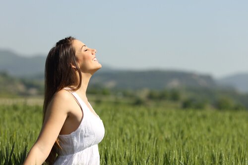 Kvinde laver beroligende vejrtrækningsøvelser i det fri
