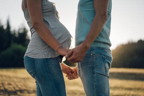 Gravid kvinde holder mand i hånden