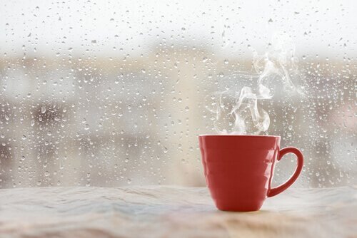 Kaffekop foran rude med regndråber på