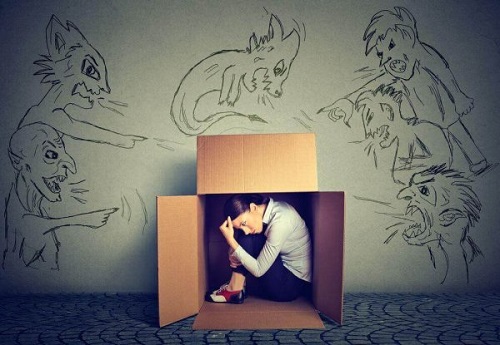 En kvinde, der gemmer sig i en papkasse