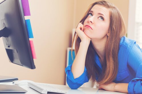 Kvinde, der keder sig ved en computer