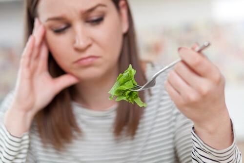 Kvinde med ortoreksi kigger dømmende på sin salat