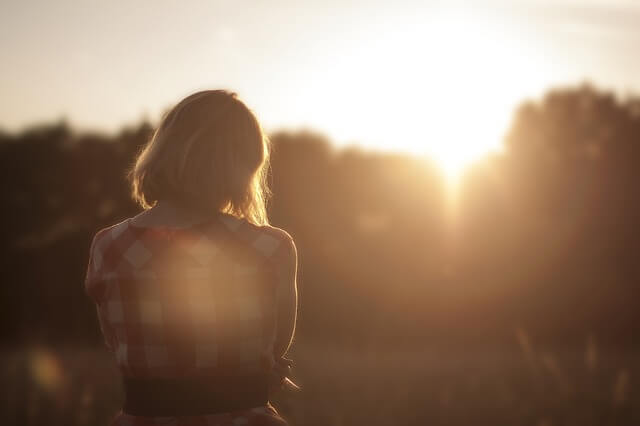 Kvinde kigger mod sol for at løfte humøret