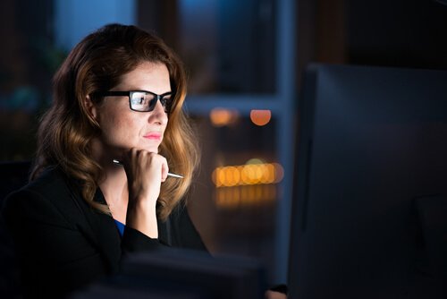 Kvinde ser på computer om natten