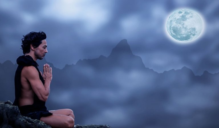 Mand mediterer ved fuldmåne og mærker, hvordan månen påvirker vores følelser