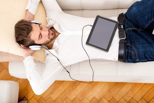 En mand, der nyder noget musik på sofaen