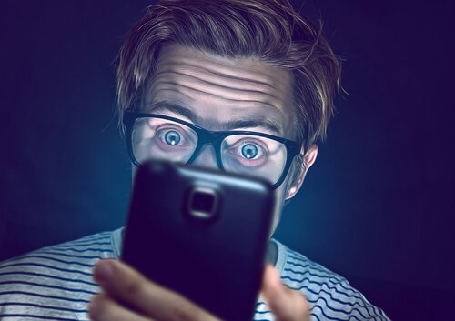 Mand ser på telefon før sengetid