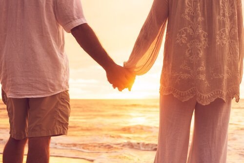 Et par der holder i hånd på en strand