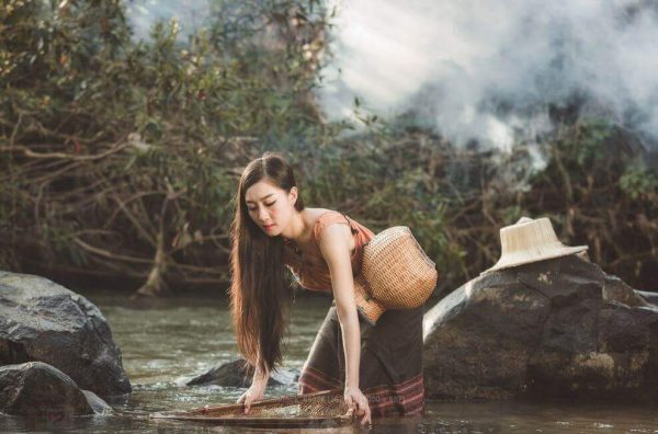 Kvinde vasker tøj i flod