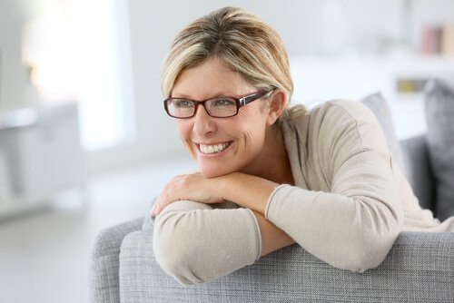 Kvinde sidder med briller sidder i sofa
