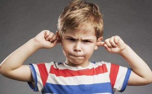 Dreng kommer fingre i ørerne