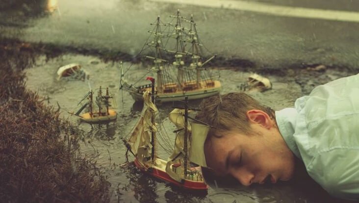 Mand sover i miniatureland med skibe