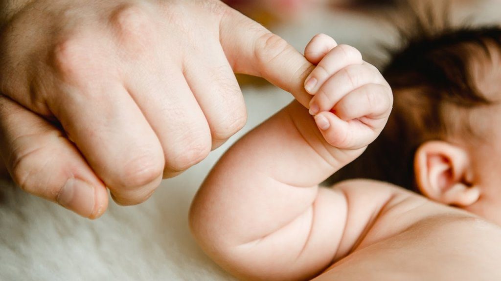 baby holder i hånd med deleforældre