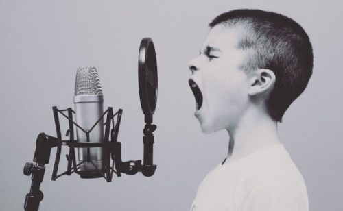 Dreng, der råber ind i en mikrofon