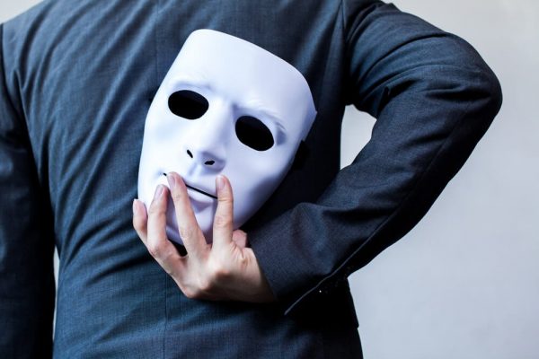 Mand med maske bag ryg