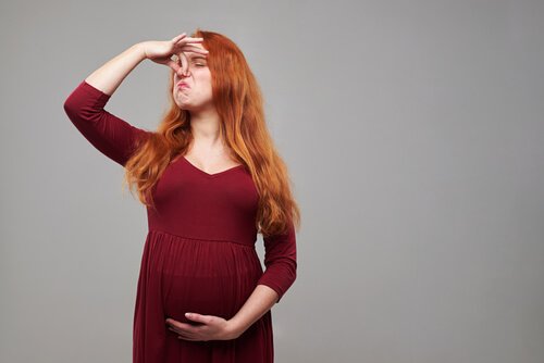 Gravid kvinde der holder sig for næsen på grund af hyperosmi
