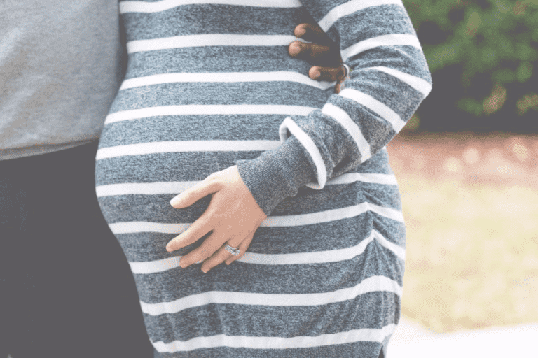 Gravid kvinde med hånd på mave