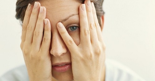 Kvinde der kigger ud gennem fingrene