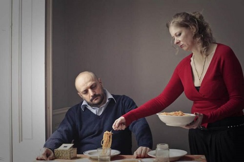 Kvinde der serverer mad for en mand
