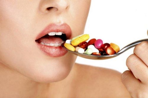 Kvinde spiser piller med en ske for at teste nocebo-effekten