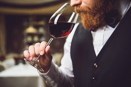 Mand med hyperosmi dufter til et glas rødvin