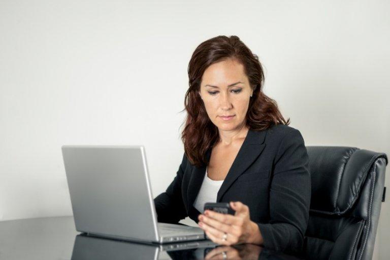 kvinde tjekker lige sin mobil på arbejdet